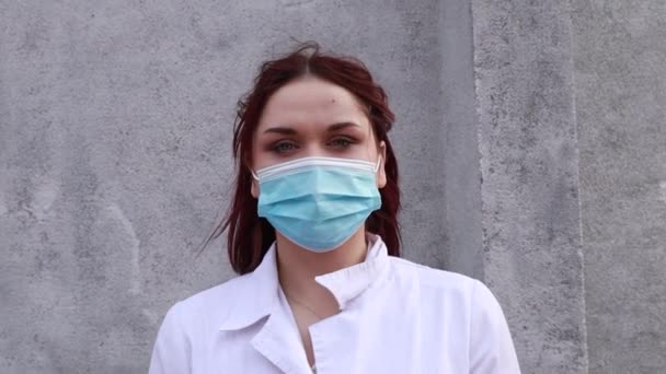 慢镜头 护工沿街行走 女医生身穿医用白衣 戴着蓝色一次性口罩和手套 — 图库视频影像