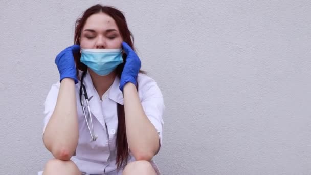 慢镜头 护理工作者在手术后感到头痛 偏头痛 女医生穿着医用白衣 蓝色一次性口罩和手套 — 图库视频影像