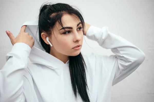 Kvinna Klädd Vit Hoodie Lyssna Musik Med Trådlösa Hörlurar Medan — Stockfoto