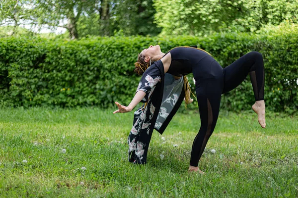 Donna Yogi Con Dreadlocks Stretching Facendo Pratica Posa Prato Verde — Foto Stock