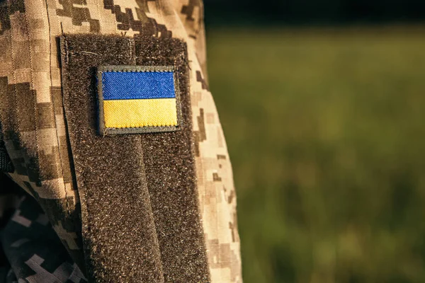 Close up velcro patch with flag of Ukraine on military uniform soldiers arm. Armed Forces of Ukraine. Ukrainian in Army.