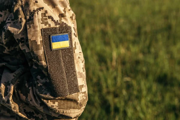 Close up velcro patch with flag of Ukraine on military uniform soldiers arm. Armed Forces of Ukraine. Ukrainian in Army.