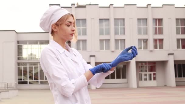 Young Female Nurse Standing Hospital Infirmary Pulls Blue Medical Disposable — Vídeo de Stock