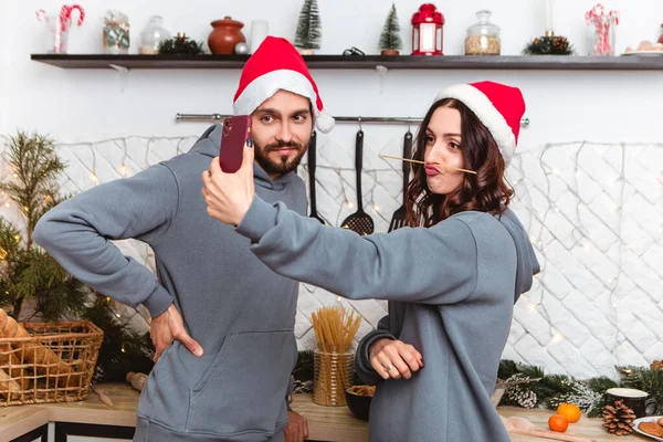 Couple Standing Kitchen Wear Red Hats Having Fun Making Faces — Stockfoto