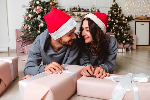 Lovely Young Romantic Couple Wear Red Hats Sitting Open Gifts — Stockfoto