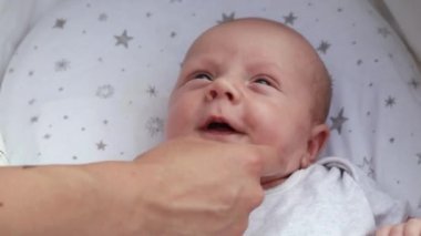 1080p yavaş çekim videosu. Bebek arabasında bebek arabasında uzanan, eğlenen, annesine bakan, gülümseyen yeni doğmuş bebeğe yakından bakın. Dışarıda sandalyede yürüyorum, temiz hava.