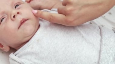 1080p yavaş çekim videosu. Bebek arabasında bebek arabasında uzanan, eğlenen, annesine bakan, gülümseyen yeni doğmuş bebeğe yakından bakın. Dışarıda sandalyede yürüyorum, temiz hava.