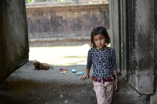 A taciturn girl and puppy playing on the temple. — Stock Photo, Image
