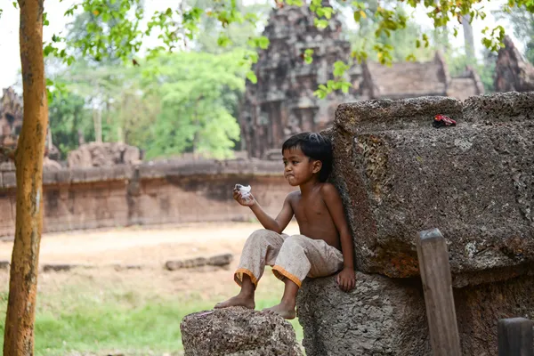 A boy sit on relaxed posture at Angkor wat Temple. (Leisurely boy) — Stock Photo, Image