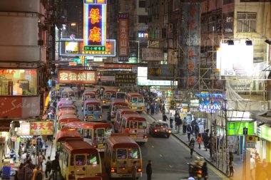 insanlar fife street, mong kok, hong kong. mong kok, hong kong, bir mini otobüs istasyonu bulunmaktadır. birçok mini otobüs bu sokakta park edilmiş.