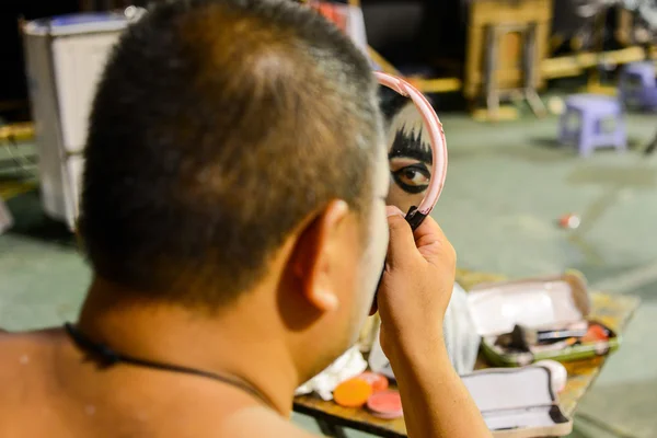 Hong Kong, China - August 18, 2014: A traditional opera actor is making up at the back stage of a traditional tea house. Generally, an actor needs 30 - 60 minutes to complete the whole process. — Stock Photo, Image