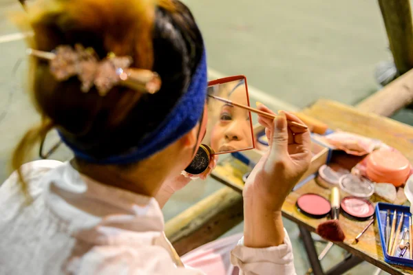 Hong kong, china - 18. August 2014: Ein traditioneller Opernsänger schminkt sich hinter der Bühne eines traditionellen Teehauses. Im Allgemeinen benötigt ein Schauspieler 30-60 Minuten, um den gesamten Prozess abzuschließen.. Stockbild