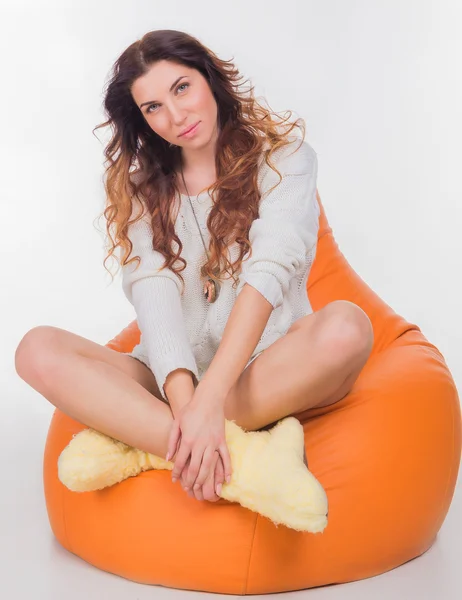 Jolie fille assise sur l'oreiller orange — Photo