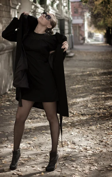 Une jeune fille en manteau noir — Photo
