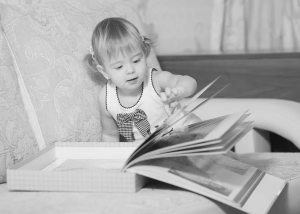 La petite fille envisage un album de photographies — Photo