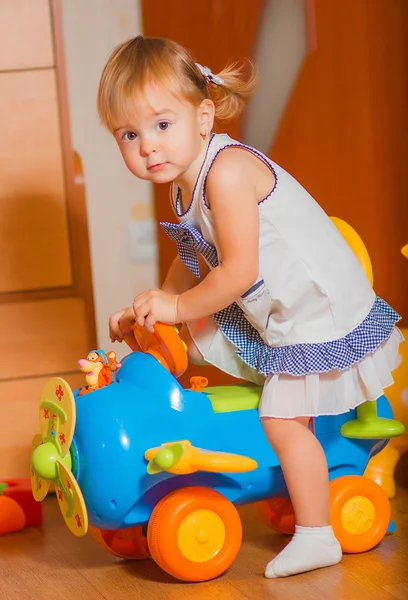 Маленькая девочка едет на игрушечной машине — стоковое фото