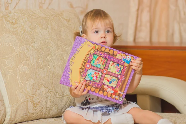 Ein kleines Mädchen hält ein Buch — Stockfoto