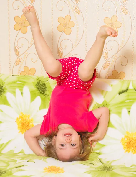 Little girl standing on his head — Stock Photo, Image