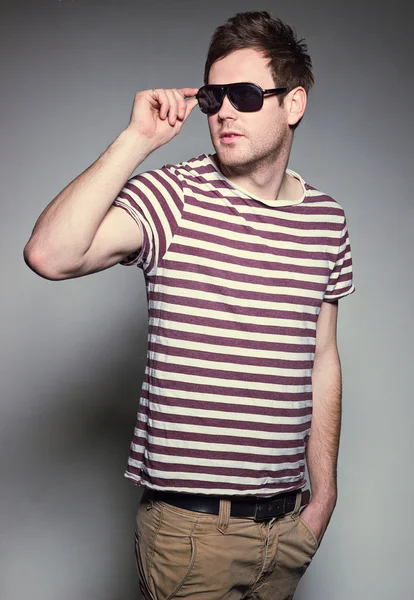 Vacker kille i en t-shirt och glasögon — Stockfoto