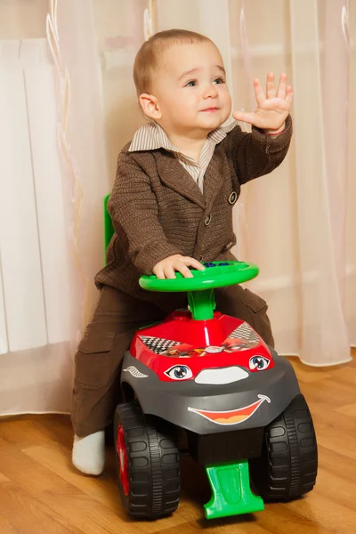 Mały chłopiec w spodnie i kurtka jest jazda na typewr — Zdjęcie stockowe