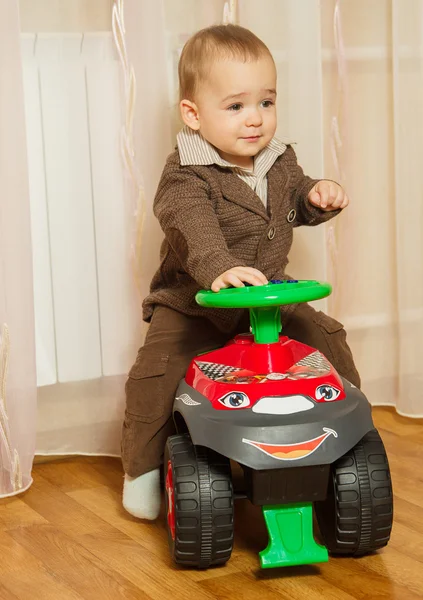 Der kleine Junge in der Hose und der Jacke fährt auf einer Schreibmaschine — Stockfoto