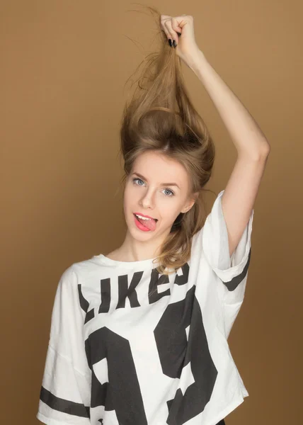 Una joven con una camiseta jugando con el pelo — Foto de Stock