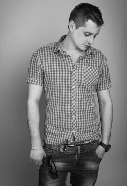 Beautiful guy in a shirt and jeans — Stock Photo, Image