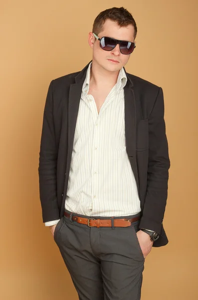 Bello, ragazzo di successo in un abito e occhiali da sole — Foto Stock
