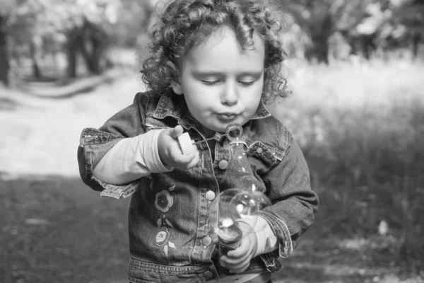 Little curly girl with soap bubbles — Stock Photo, Image