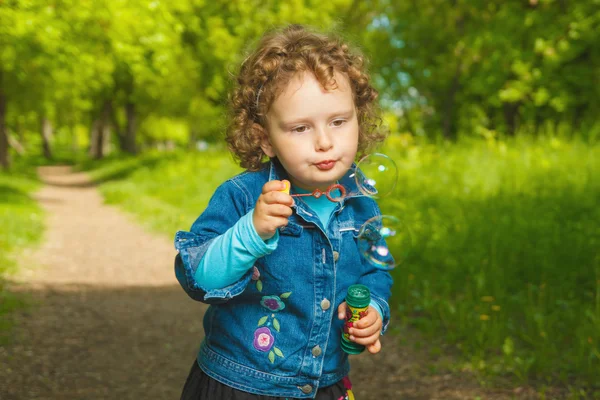 Little curly girl with soap bubbles — Stock Photo, Image