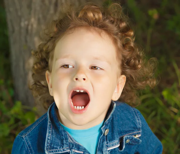 Little curly girl opens her mouth — Stock Photo, Image