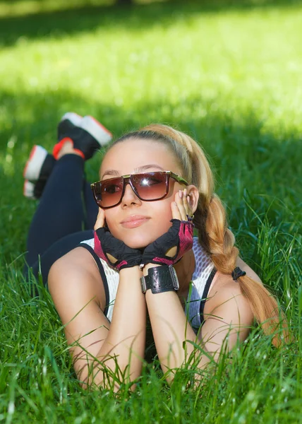 Belle fille athlétique souriant couché sur l'herbe — Photo