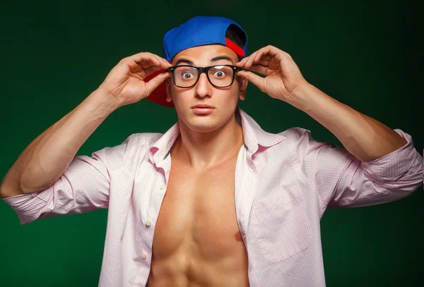 sports guy with glasses wearing a cap and shirt shows surprise