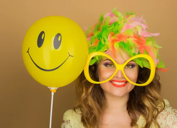 Ragazza allegra in una parrucca luminosa e grandi bicchieri che tengono un palloncino — Foto Stock