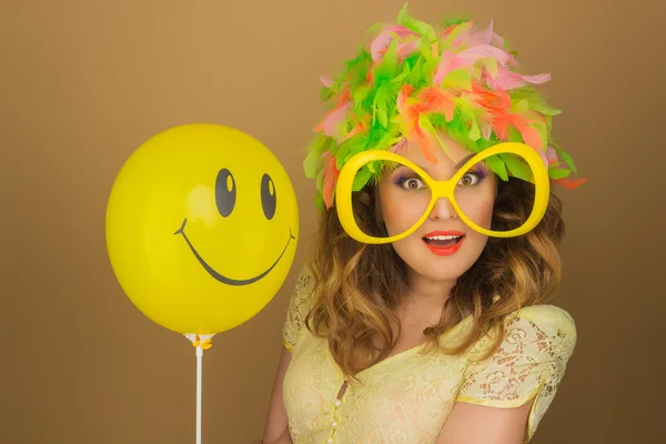 Schönes Mädchen mit heller Perücke und großer Brille, die einen Luftballon hält — Stockfoto