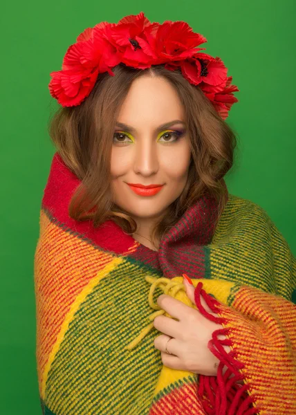 Menina bonita com flores em seu cabelo escondendo um cobertor — Fotografia de Stock