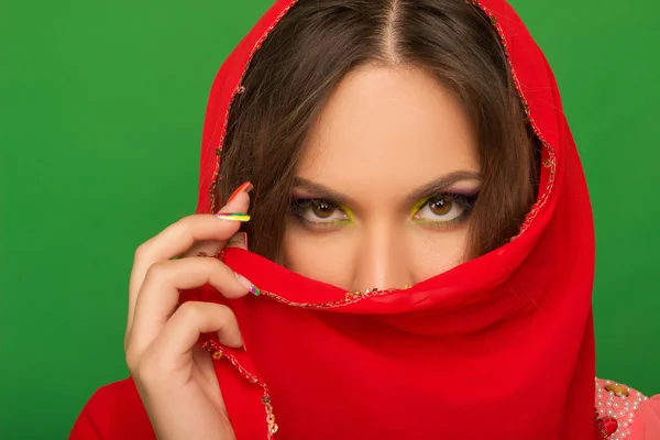 Retrato de uma menina cobrindo a boca com um lenço vermelho — Fotografia de Stock