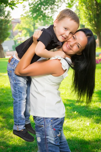 Junge Mutter hält ihren Sohn auf dem Arm — Stockfoto