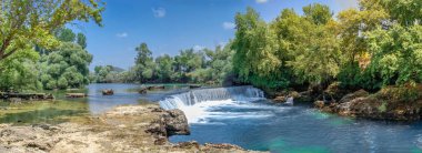 Güneşli bir yaz gününde Türkiye 'nin Antalya ilinde Manavgat şelalesi ve nehri