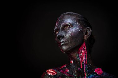 Mystical woman makeup with sparkles and luminous elements on a dark background