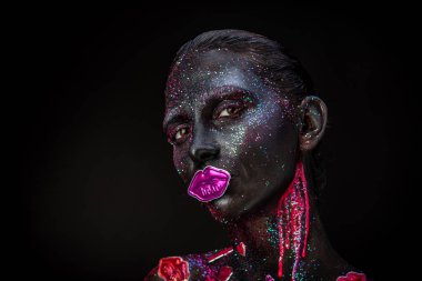 Mystical woman makeup with sparkles and luminous elements on a dark background