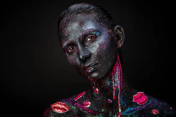 Mystical woman makeup with sparkles and luminous elements on a dark background