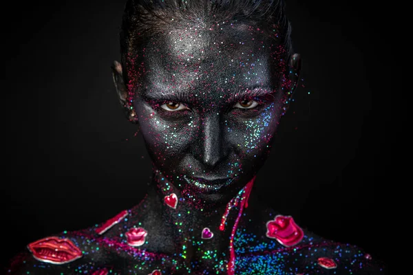 Mystical woman makeup with sparkles and luminous elements on a dark background