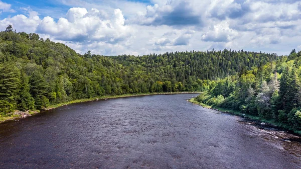 Drone View of Green Mountain Landscape, Summer Season in Canada, Water Stream flowing between Forest. 