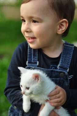 Beyaz bir kedi ile tatlı çocuk