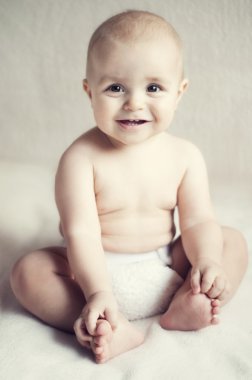 yatakta oturmuş mutlu sevimli bebek