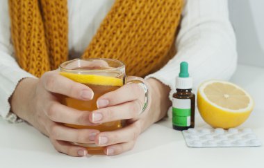 Vitaminler, ilaçlar ve yakalanmış bir kadın için limonlu sıcak çay