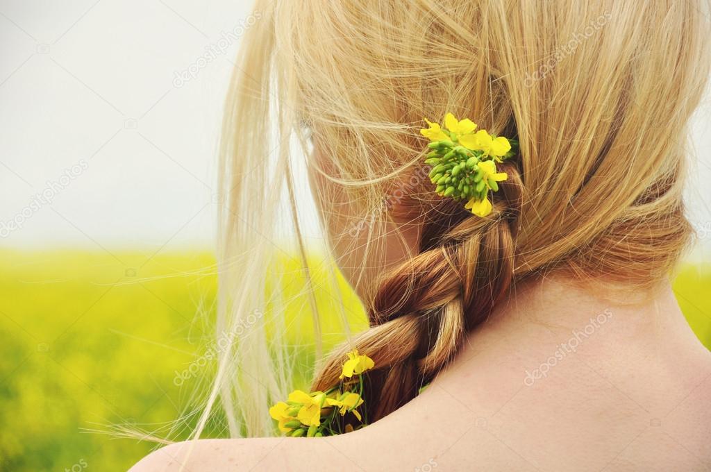 Romantic girl on a sunny day in the flowering yellow field