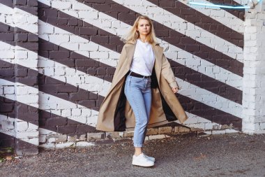 Siyah-beyaz paltolu bir kadın siyah-beyaz bir paltonun önünde dans ediyor. Logo için bir yeri olan parlak karşıtlık resmi.