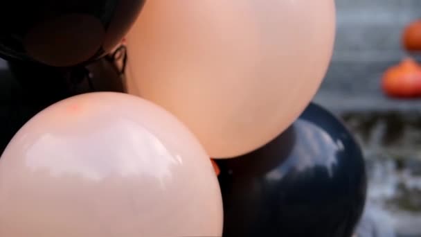 Mädchen guckt auf der Halloween-Party aus Luftballons. — Stockvideo